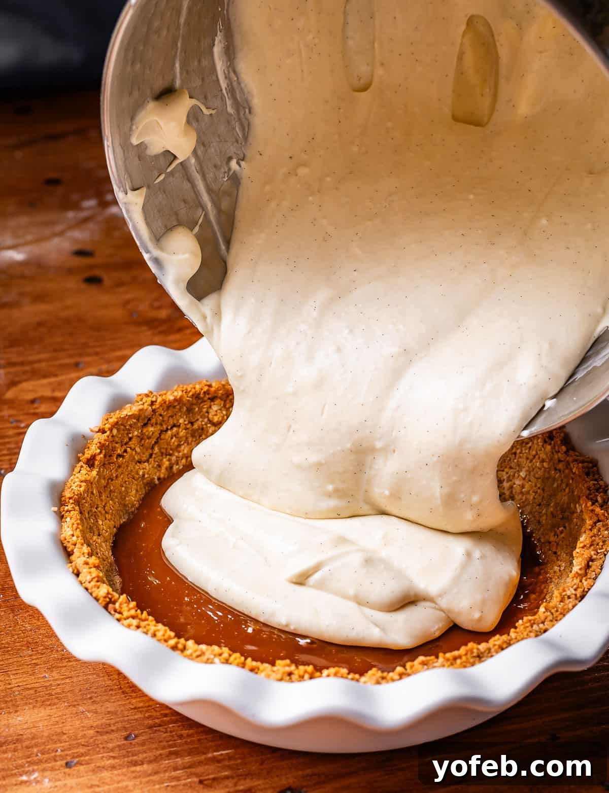 Luscious Caramel Swirled Coconut Cream Pie 18 pouring whipped cream and coconut custard mixture into pie dish over caramel and crust.