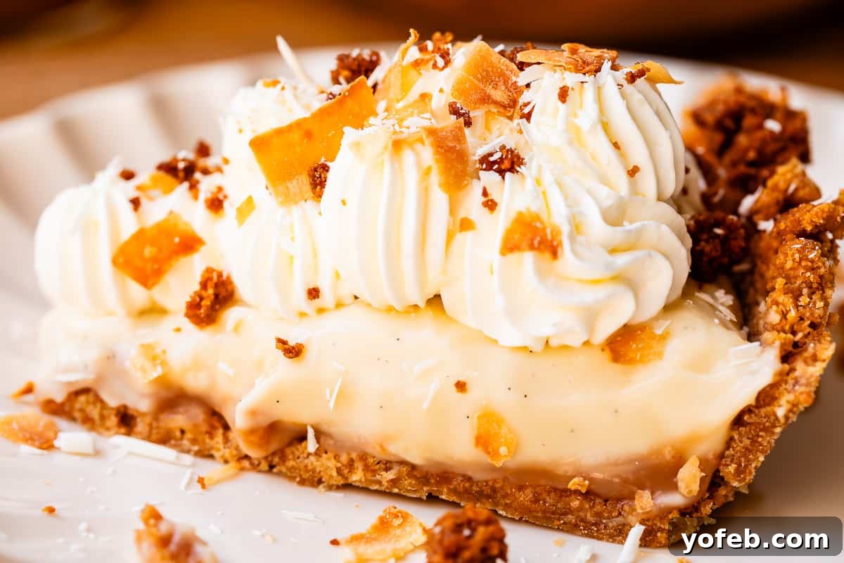 Luscious Caramel Swirled Coconut Cream Pie 21 slice of coconut cream pie on a plate with whipped cream topping and toasted coconut.