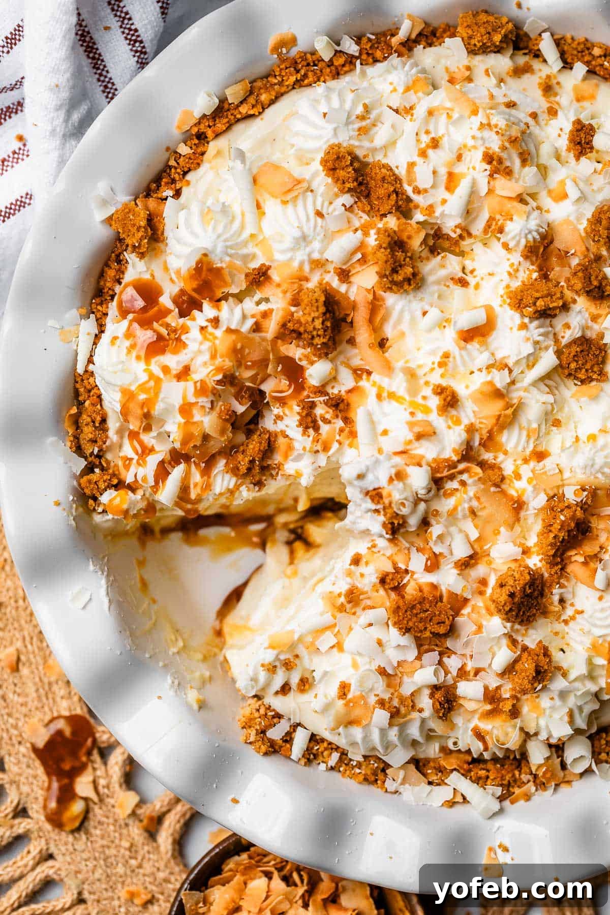 Luscious Caramel Swirled Coconut Cream Pie 22 overhead shot of coconut cream pie in a white dish with whipped cream topping.