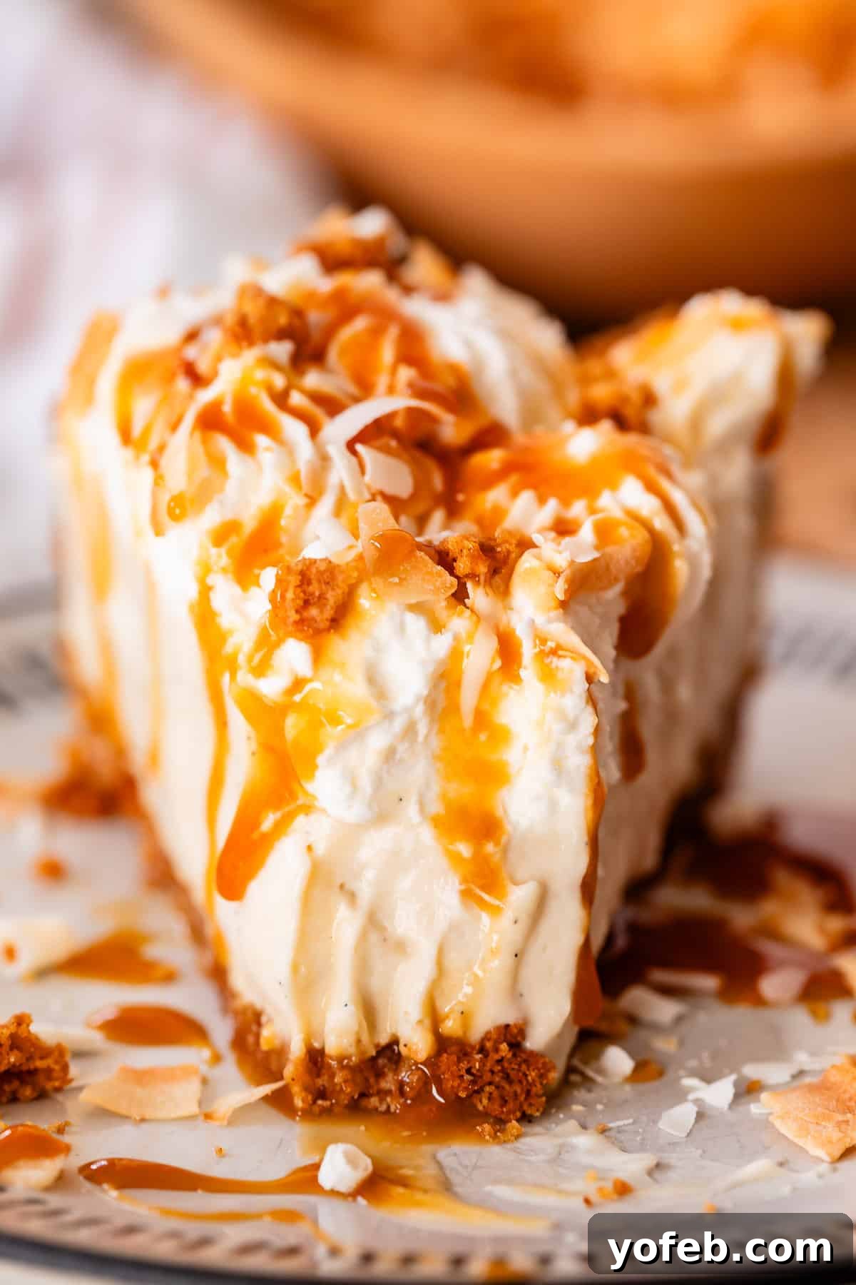 Luscious Caramel Swirled Coconut Cream Pie 23 straight on shot of slice of coconut pie with a bite taken out.