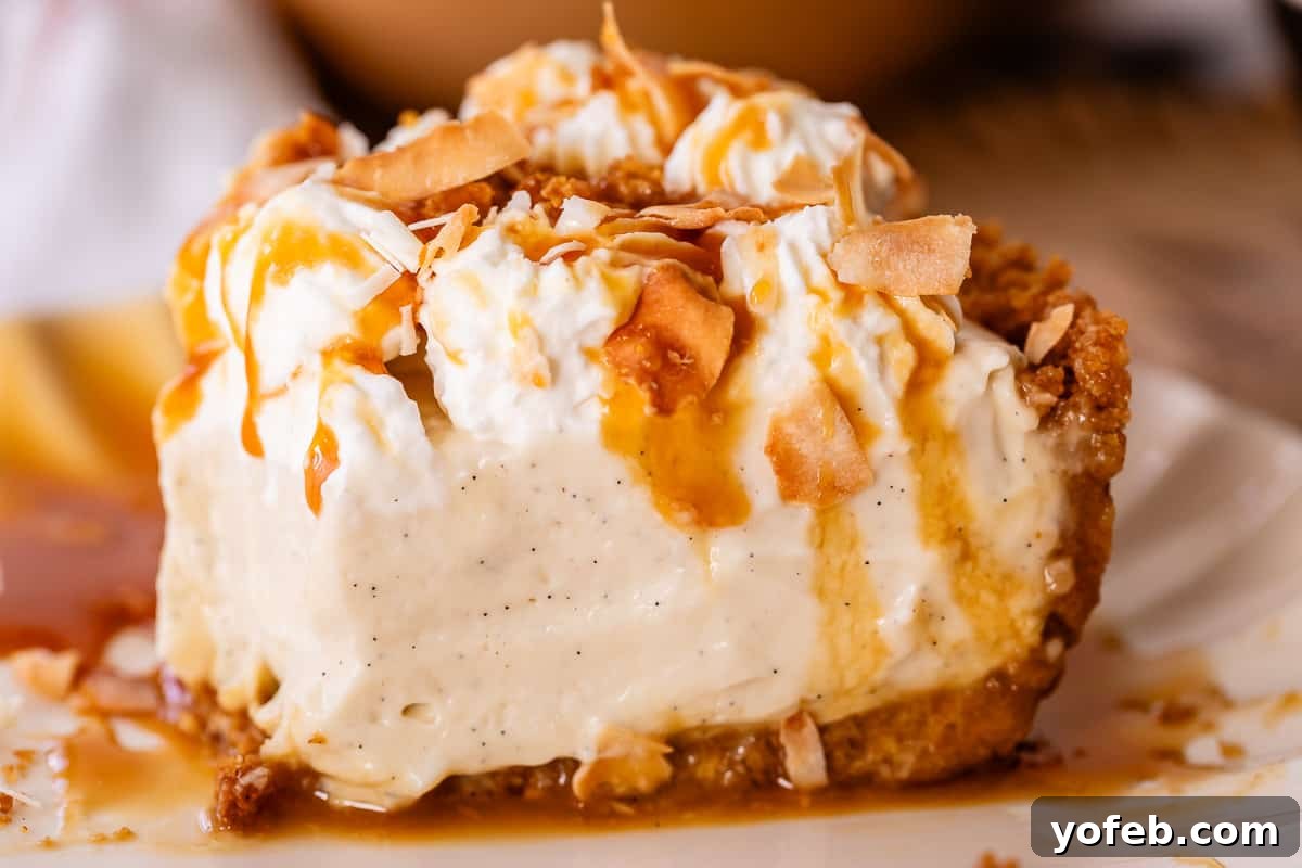 Luscious Caramel Swirled Coconut Cream Pie 24 coconut cream pie on a plate from the side with caramel on the plate.