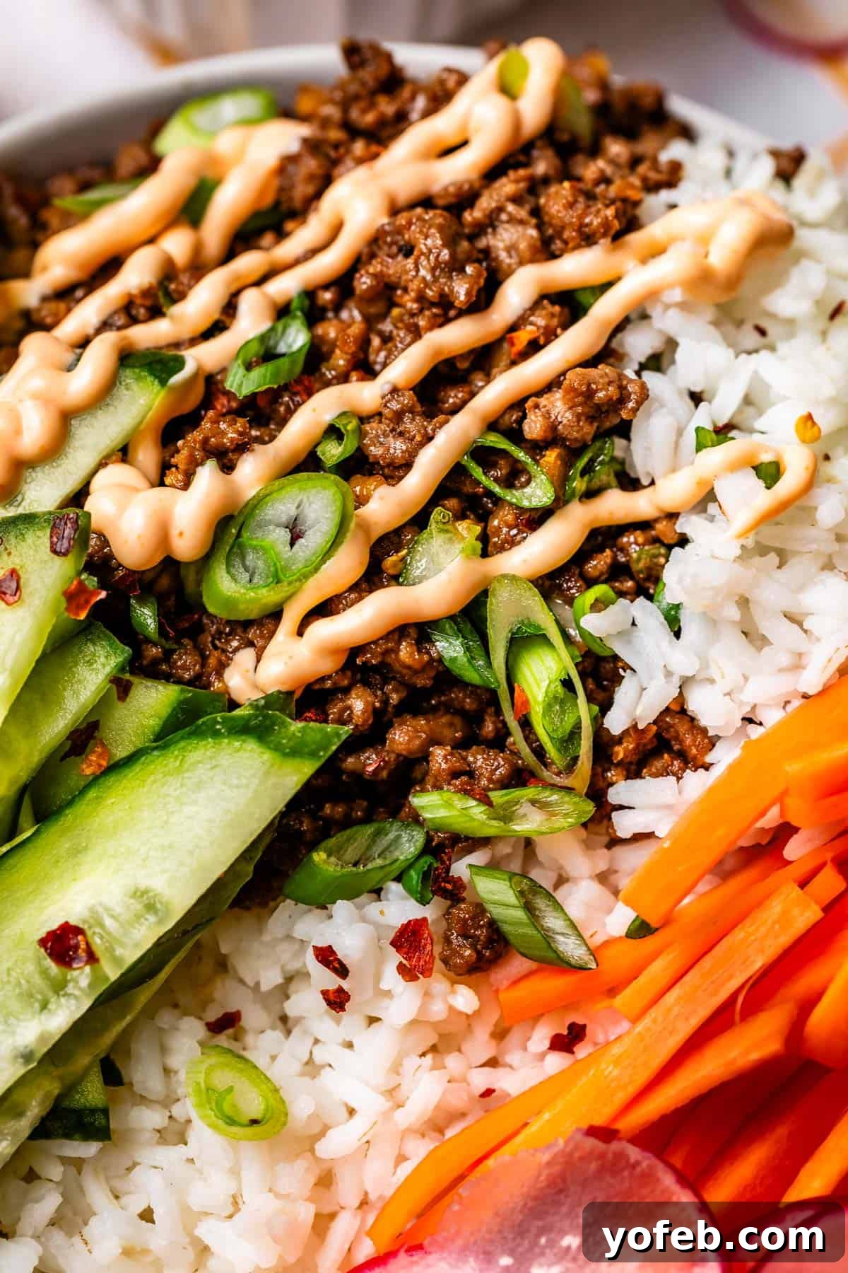 Easy 30-Minute Korean Beef 12 A close-up of a Korean beef and rice bowl, beautifully drizzled with creamy Sriracha mayo, highlighting the delicious texture and vibrant colors.