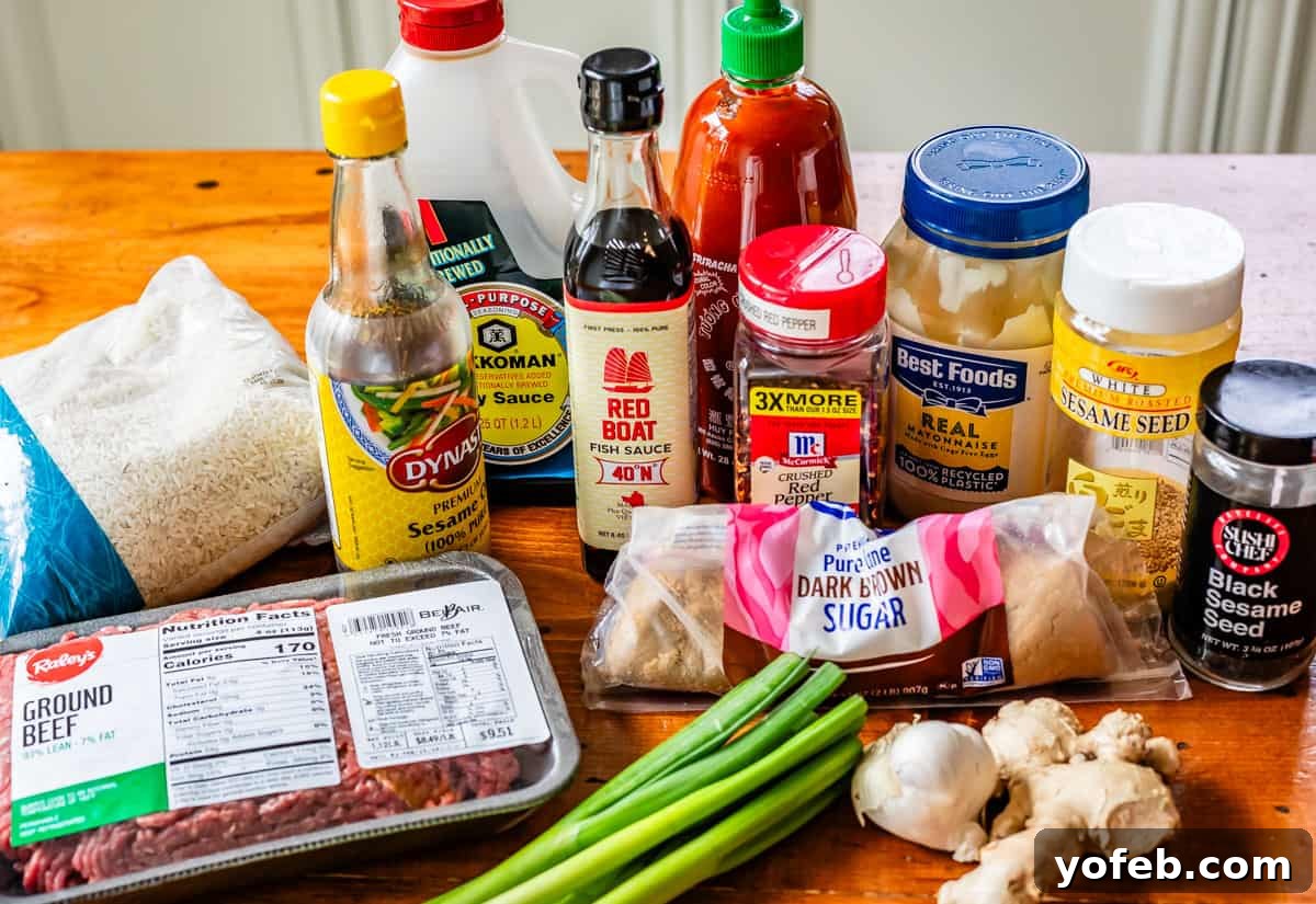 Easy 30-Minute Korean Beef 6 A flat lay of all the Korean beef ingredients: lean ground beef, bottles of sesame oil, soy sauce, fish sauce, dark brown sugar, fresh garlic, ginger, green onions, and red pepper flakes.