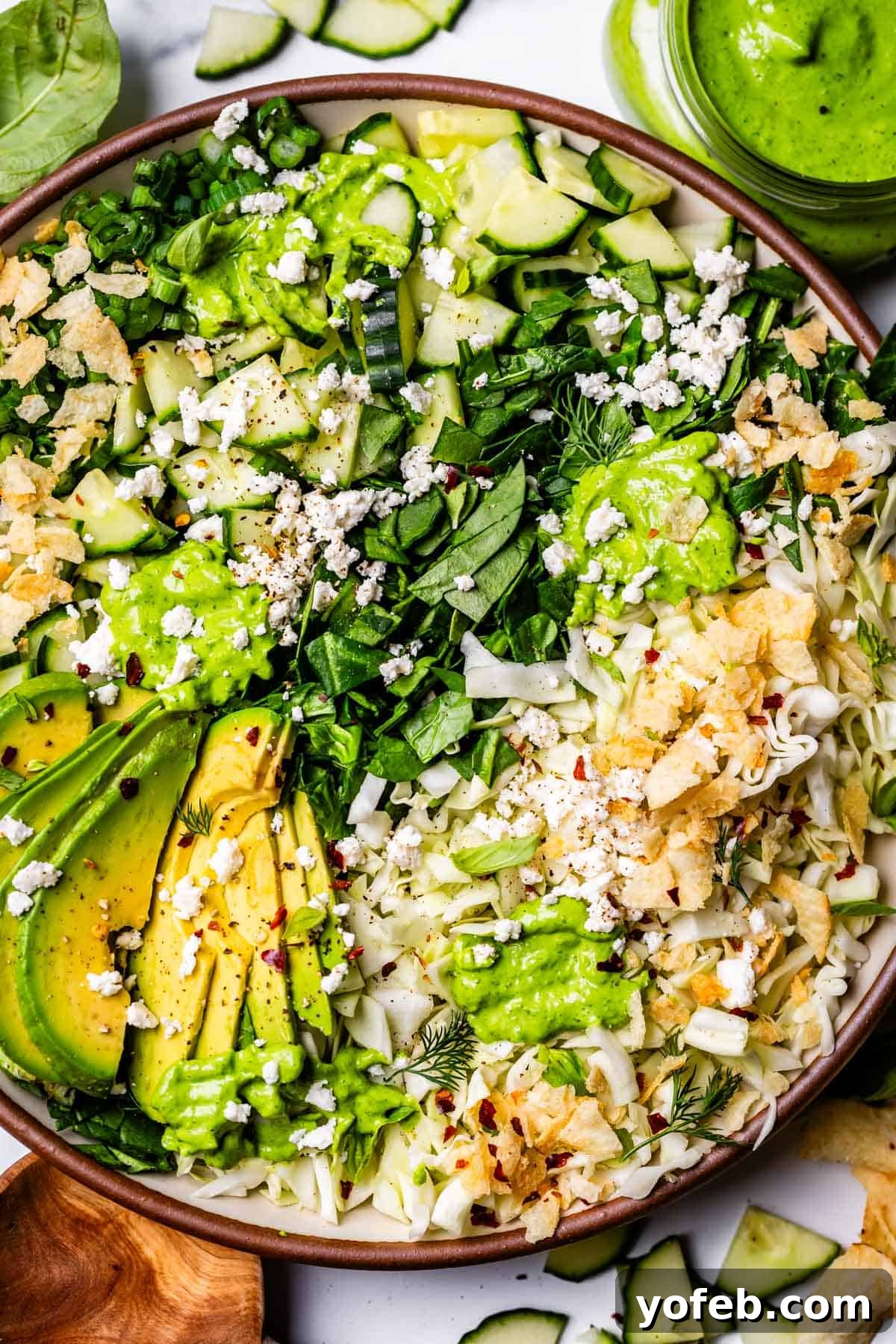 The Ultimate Green Goddess Salad 9 plate of green goddess salad topped with avocado and feta cheese.