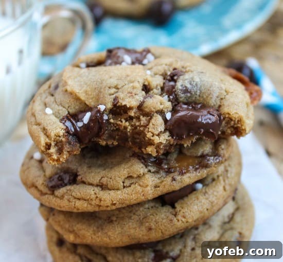 Decadent Caramel Butterscotch Cookies 5 A tempting stack of brown butter butterscotch caramel cookies artfully arranged next to a refreshing glass of milk, emphasizing their golden hue and soft texture.
