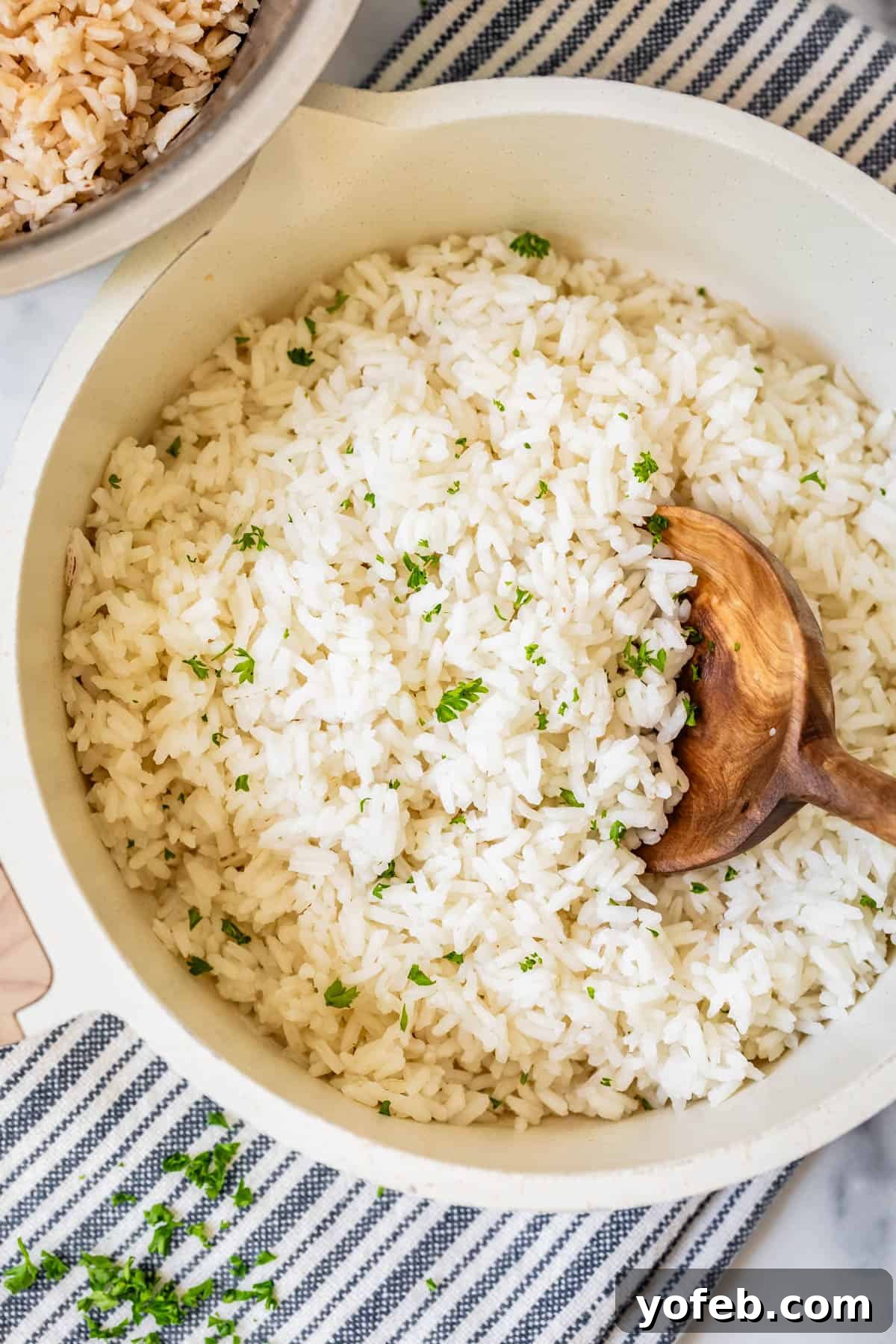 Perfect Stovetop Rice Every Time 13 Beautifully cooked white rice in a pot, fluffed and garnished with fresh parsley, ready to be served.