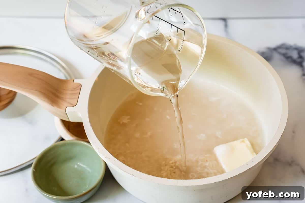 Perfect Stovetop Rice Every Time 9 Preparing rice for stovetop cooking: pouring measured water into a pot containing dry rice and a pat of butter.