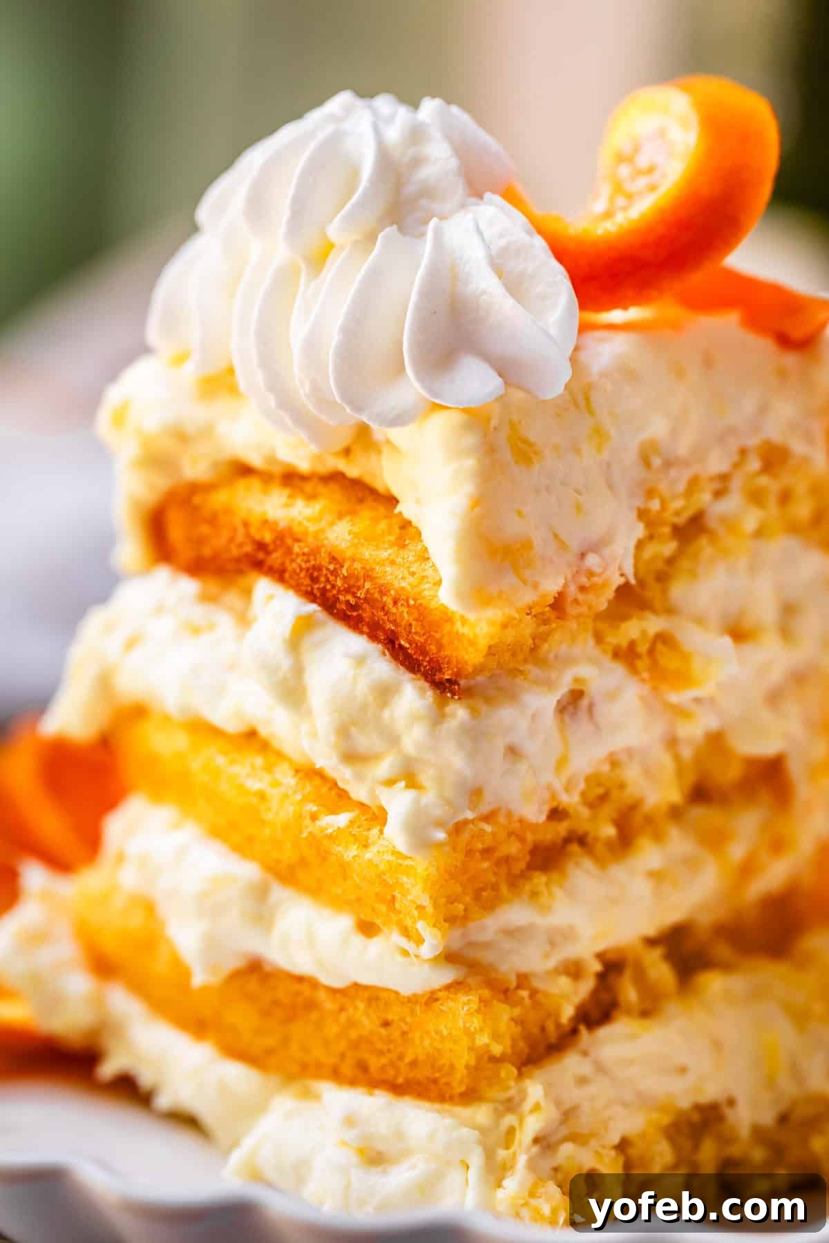 Golden Pineapple Mandarin Cake 19 piece of 8 layer pig pickin' cake on a ceramic plate with scalloped edges.