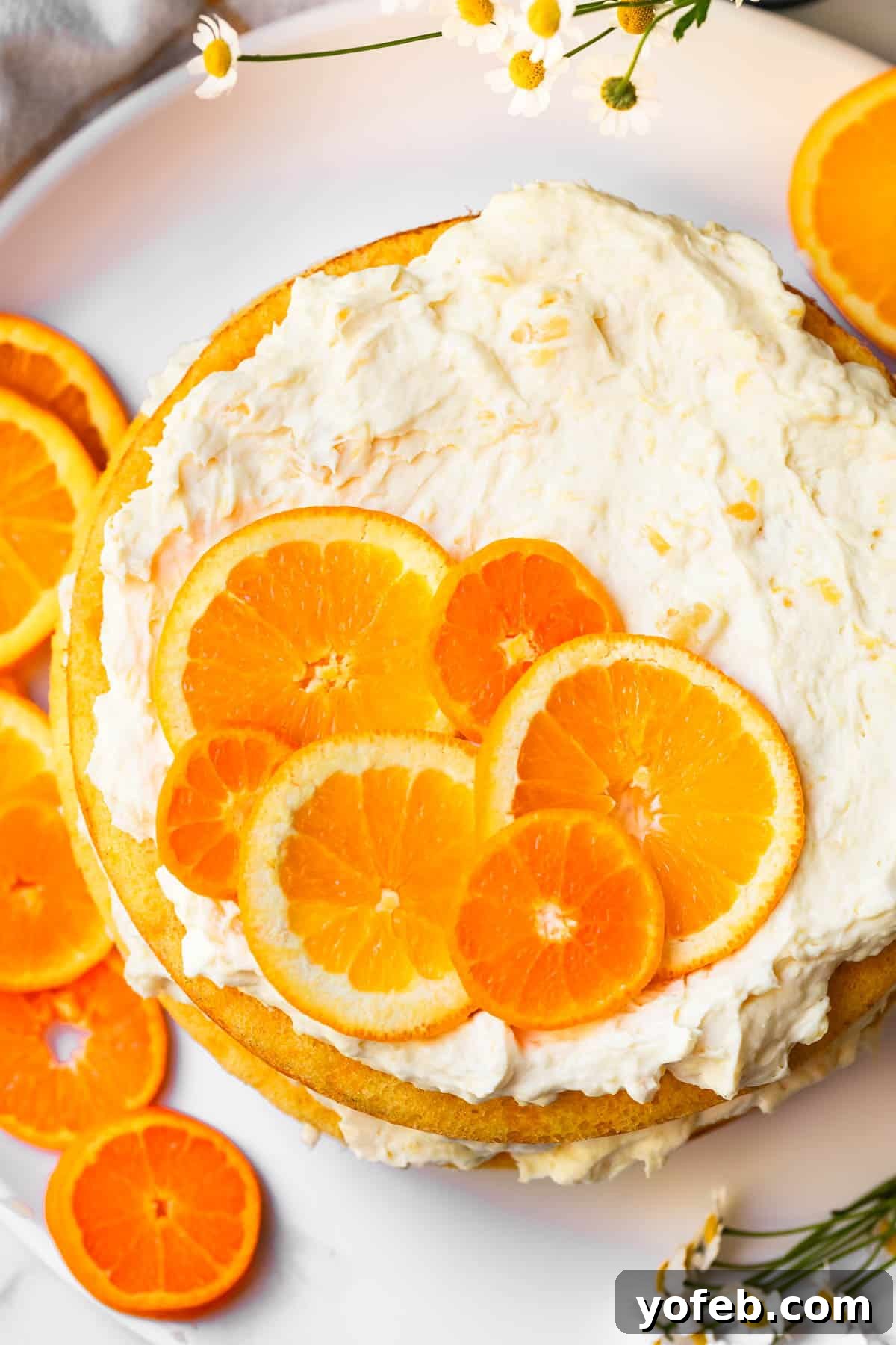 Golden Pineapple Mandarin Cake 4 top of a round, decorated pig picking cake with orange slice garnish.