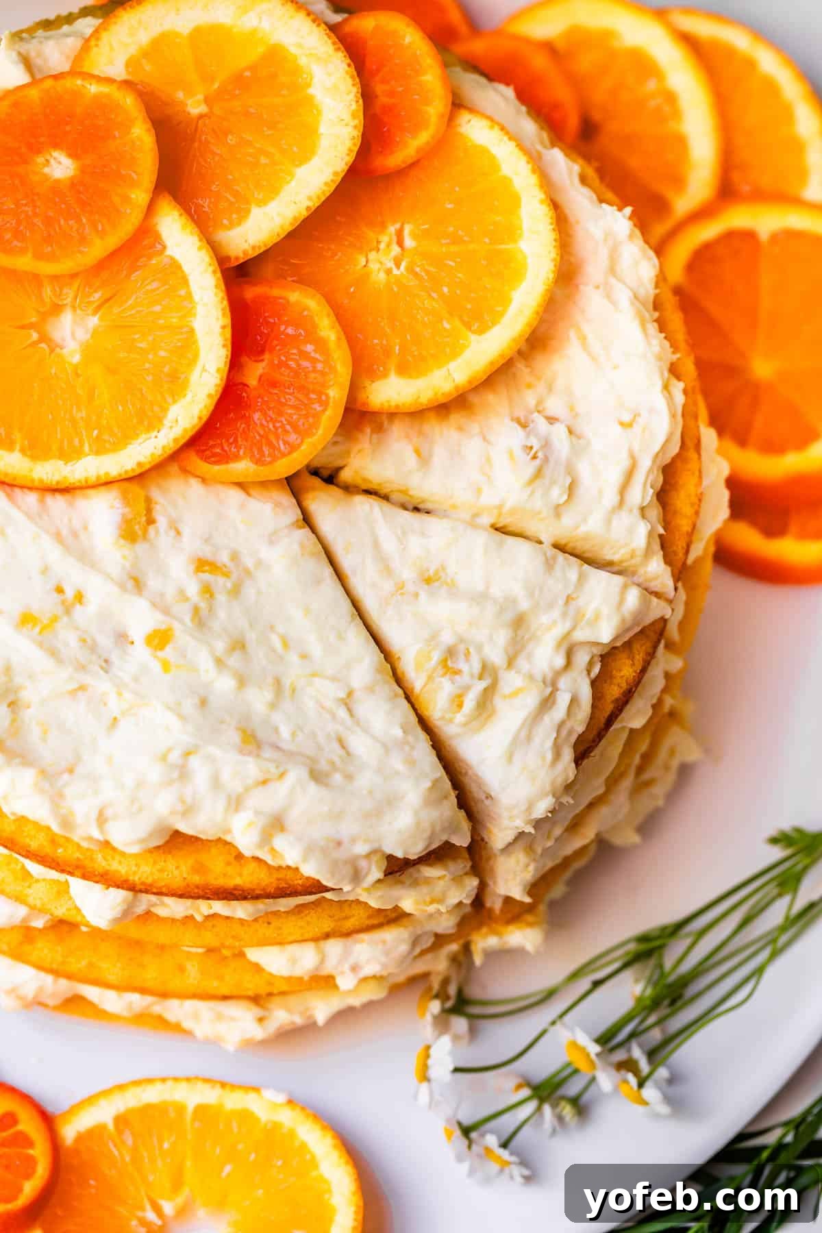 Golden Pineapple Mandarin Cake 7 whole pig pickin' cake with a slice cur but not removed, and orange slices as garnish.