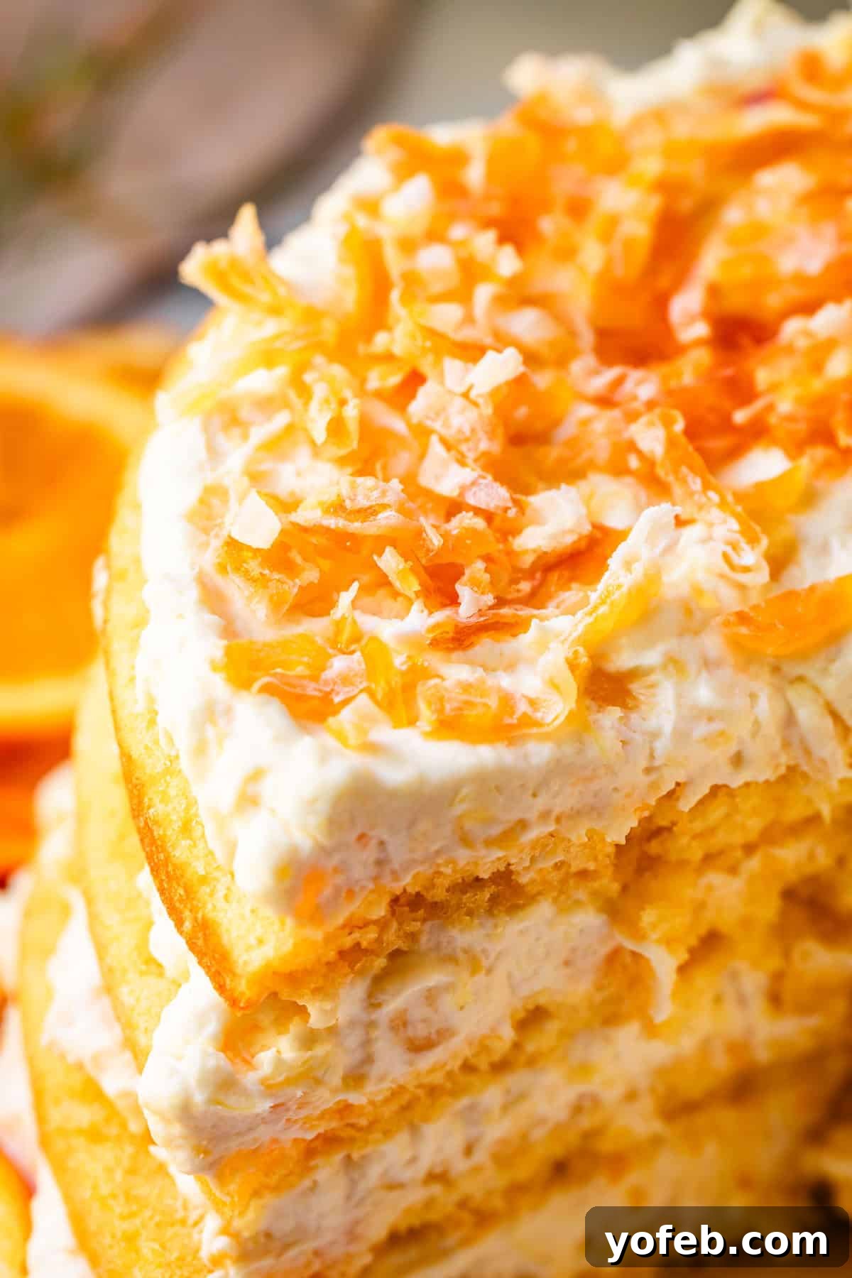 Golden Pineapple Mandarin Cake 8 4 layer pig pickin' cake with golden cake and topping, plus chopped dried mandarin oranges as garnish.