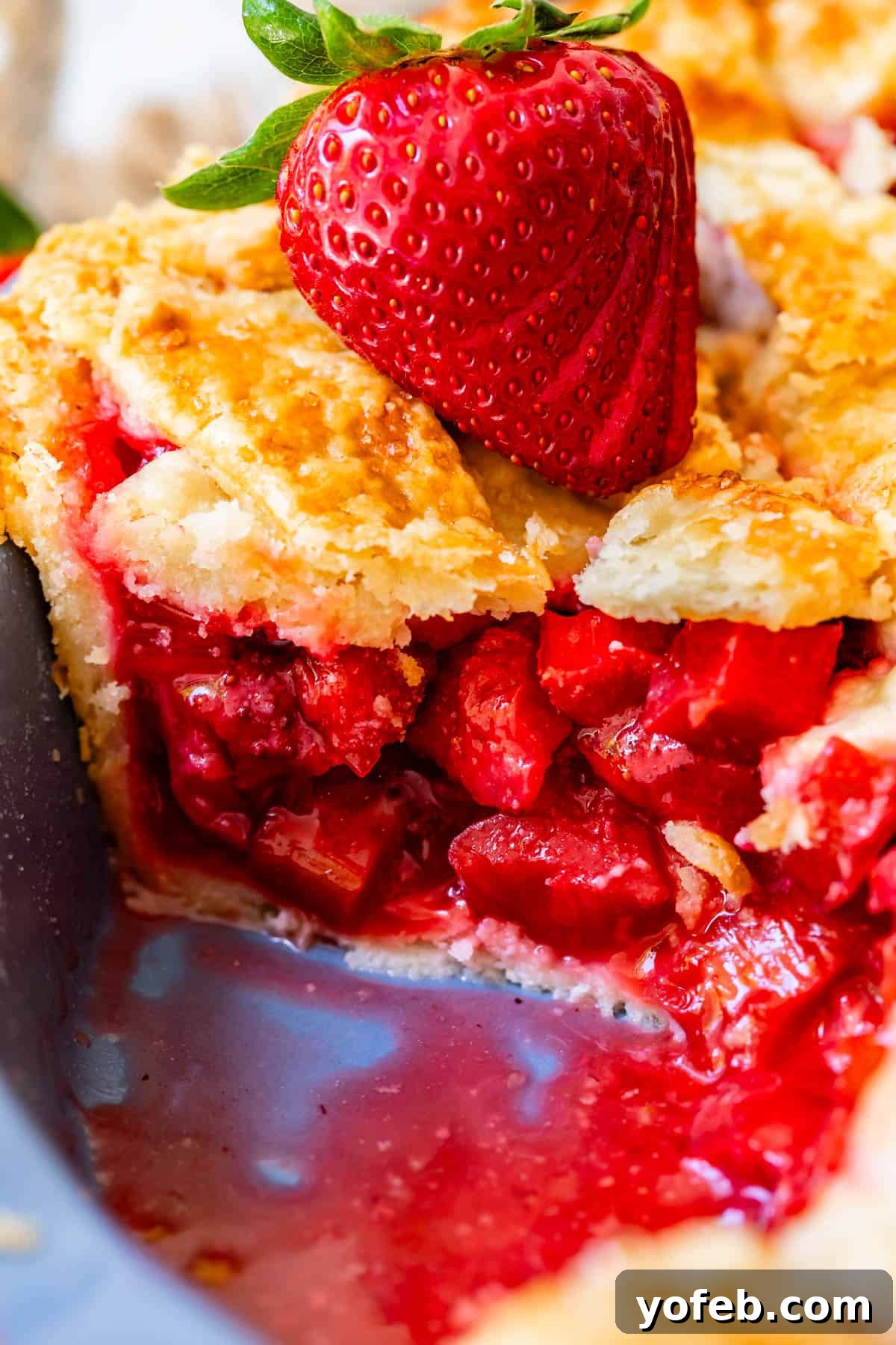 Summer's Sweet & Tart Strawberry Rhubarb Pie 26 looking at the side of a piece of pie with all the strawberry and rhubarb filling showing.