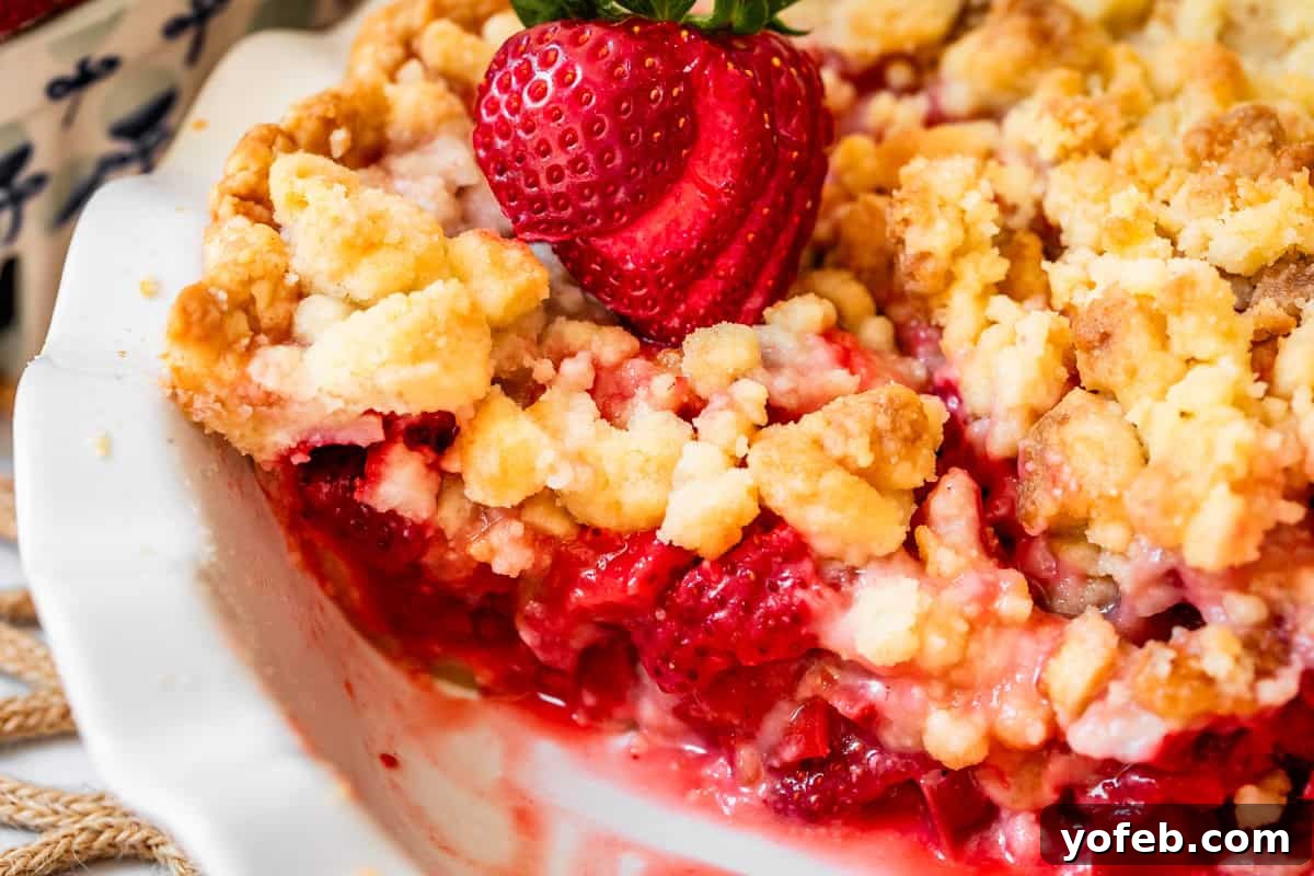 Summer's Sweet & Tart Strawberry Rhubarb Pie 27 baked strawberry rhubarb pie with crumble topping in pie pan with slice removed.