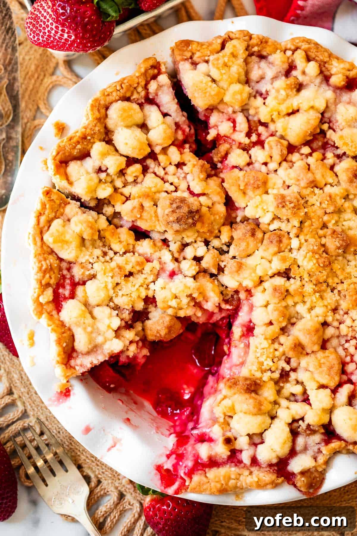 Summer's Sweet & Tart Strawberry Rhubarb Pie 7 whole crumble topped rhubarb strawberry pie with slices cut and one removed from pan.
