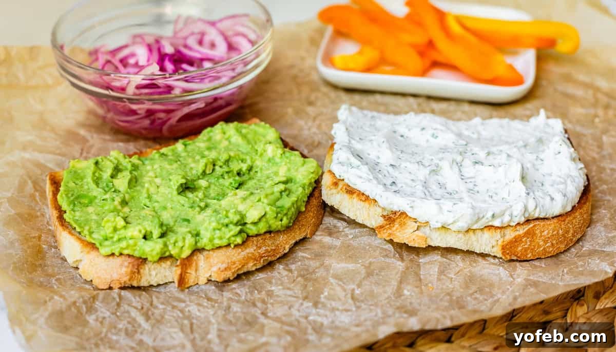 Vibrant Vegetable Stack 15 two slices of bread with cream cheese spread on one and mashed avocado on the other.