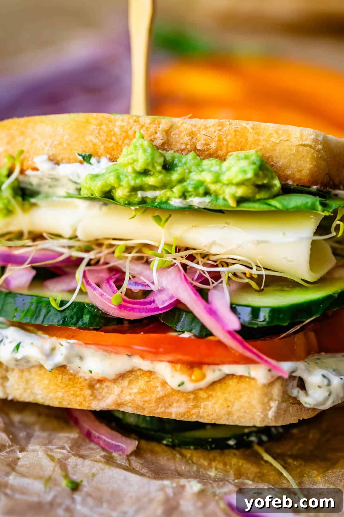 Vibrant Vegetable Stack 7 sideways view of a veggie sandwich with cheese showing all the layers and a skewr in the top.