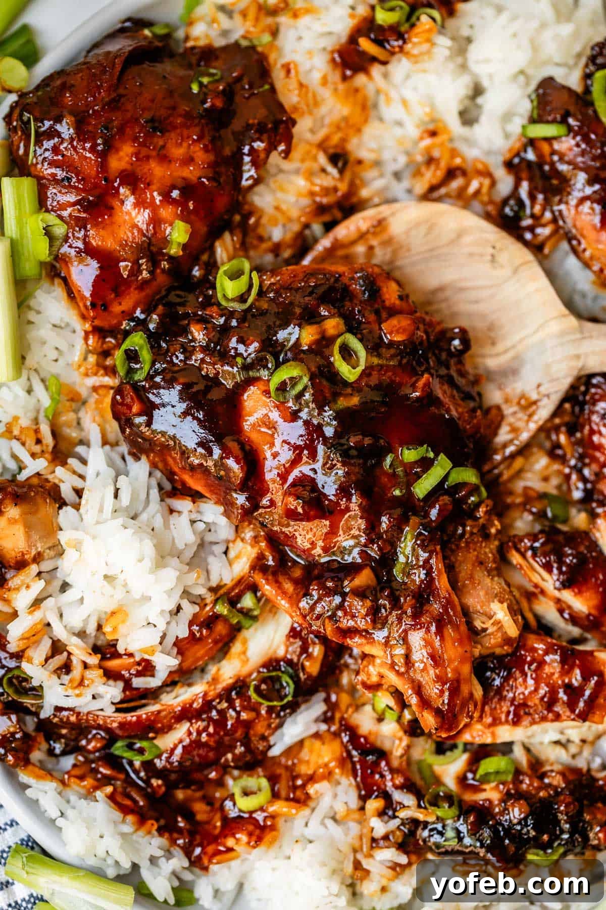 Easy Honey Garlic Chicken Slow Cooker Instant Pot 3 wooden spoon picking up a chicken thigh topped with honey garlic sauce.
