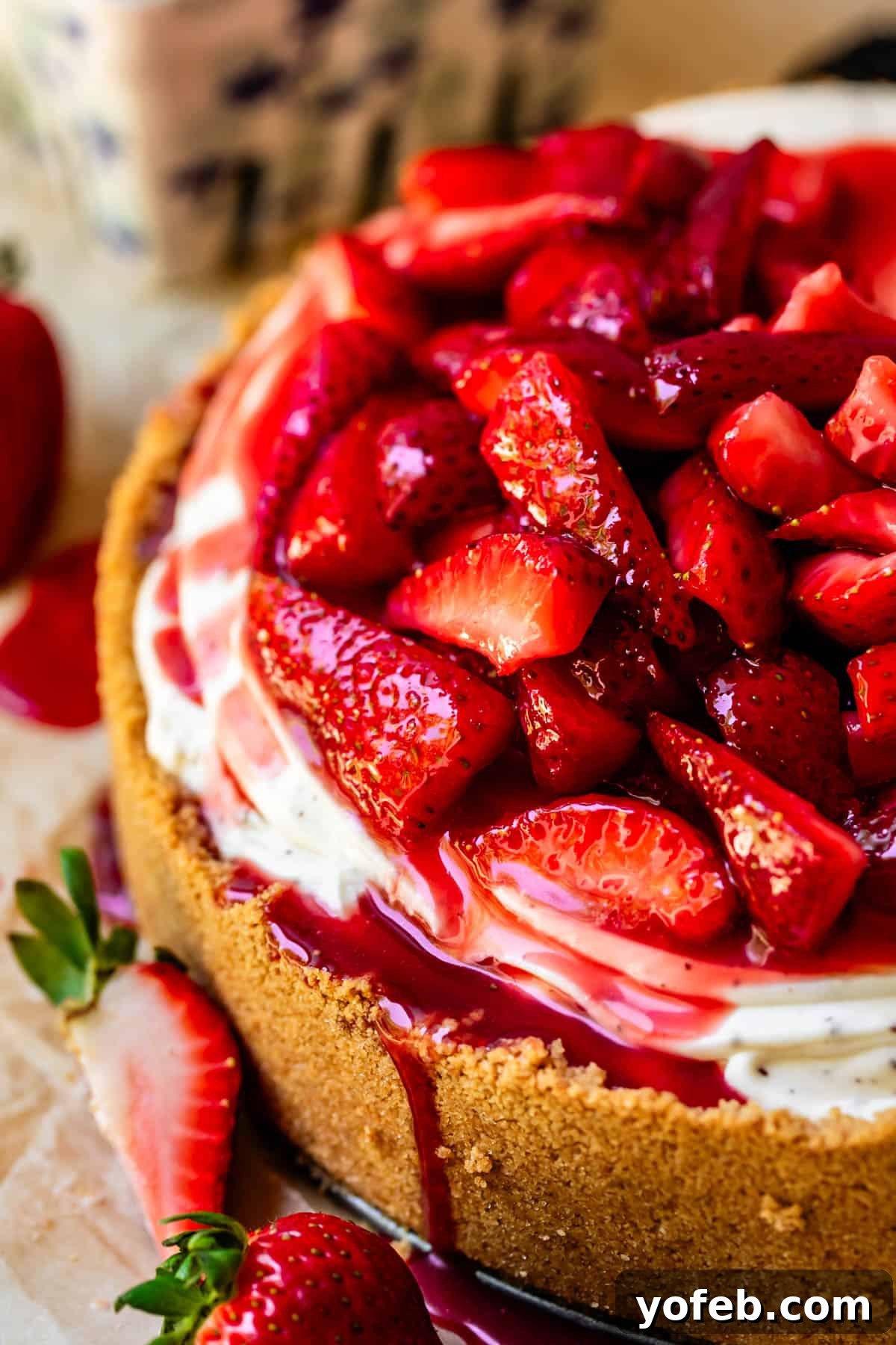 The Ultimate No Bake Cheesecake 34 no bake cheesecake with mounded fresh strawberry topping and juice dripping down.