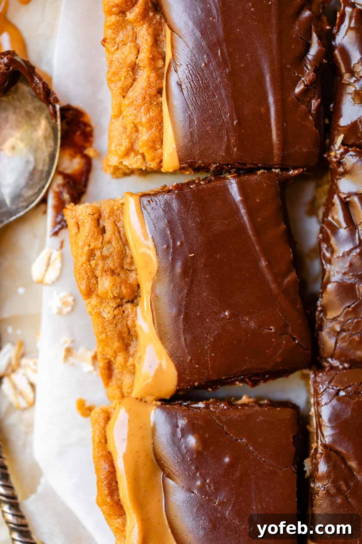 Classic Cafeteria Peanut Butter Bars 20 A close-up of three perfectly cut Lunch Lady Peanut Butter Bars, stacked to showcase their inviting layers of oatmeal cookie, peanut butter, and thick chocolate frosting.
