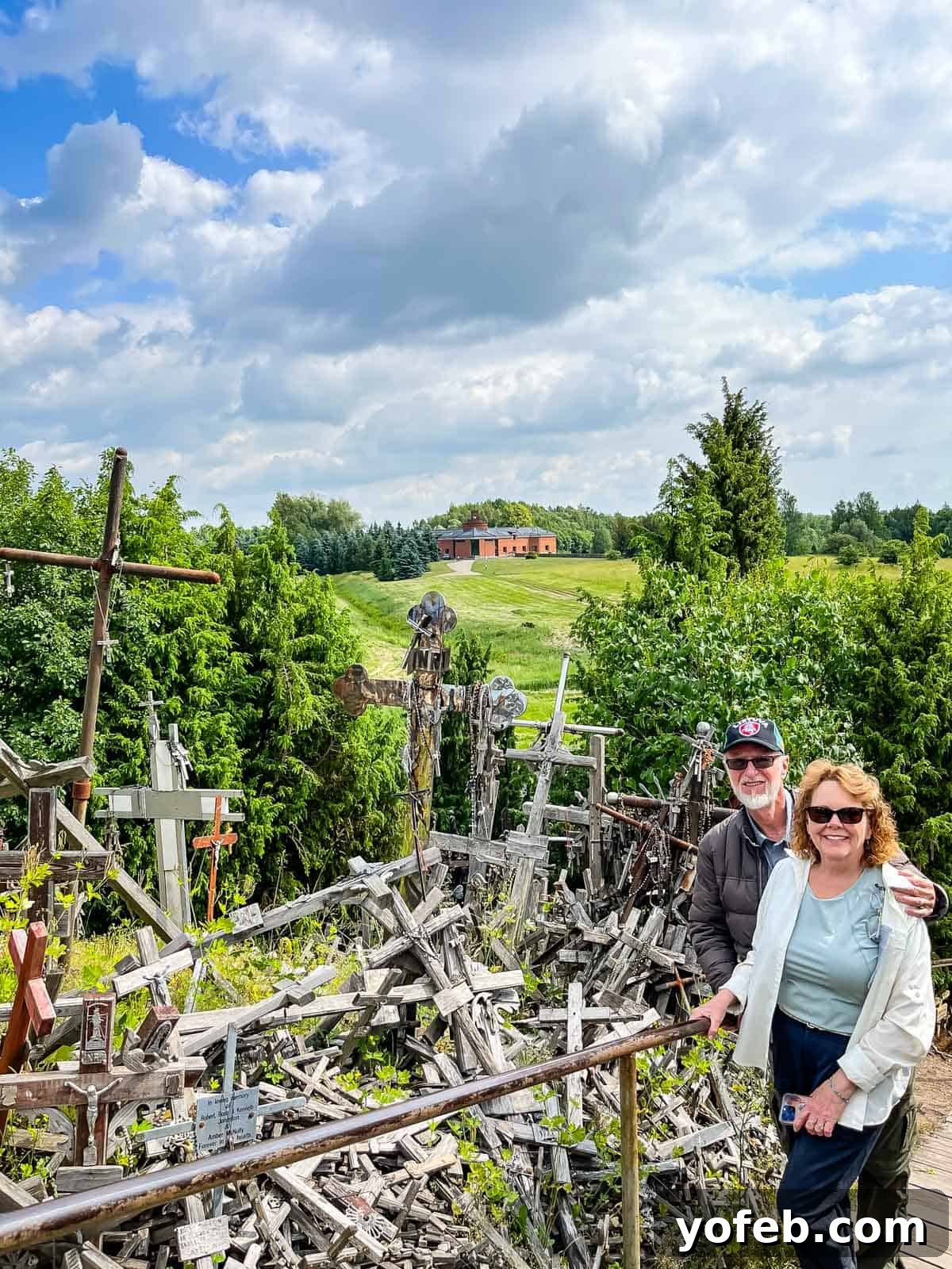 Unlock the Charm of the Baltics 49 A man and a woman standing amidst countless crosses at the Hill of Crosses in Lithuania.