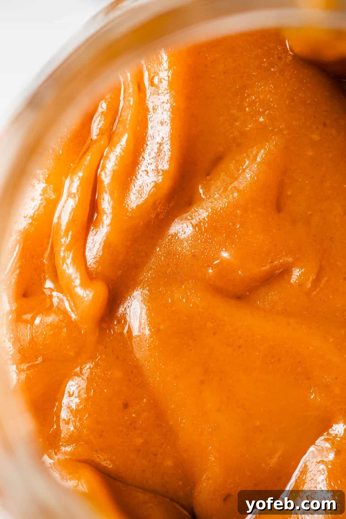 Dreamy Salted Caramel Sauce 24 A close-up view of rich, fudgy salted caramel sauce stored in a glass jar, showcasing its enticing texture.