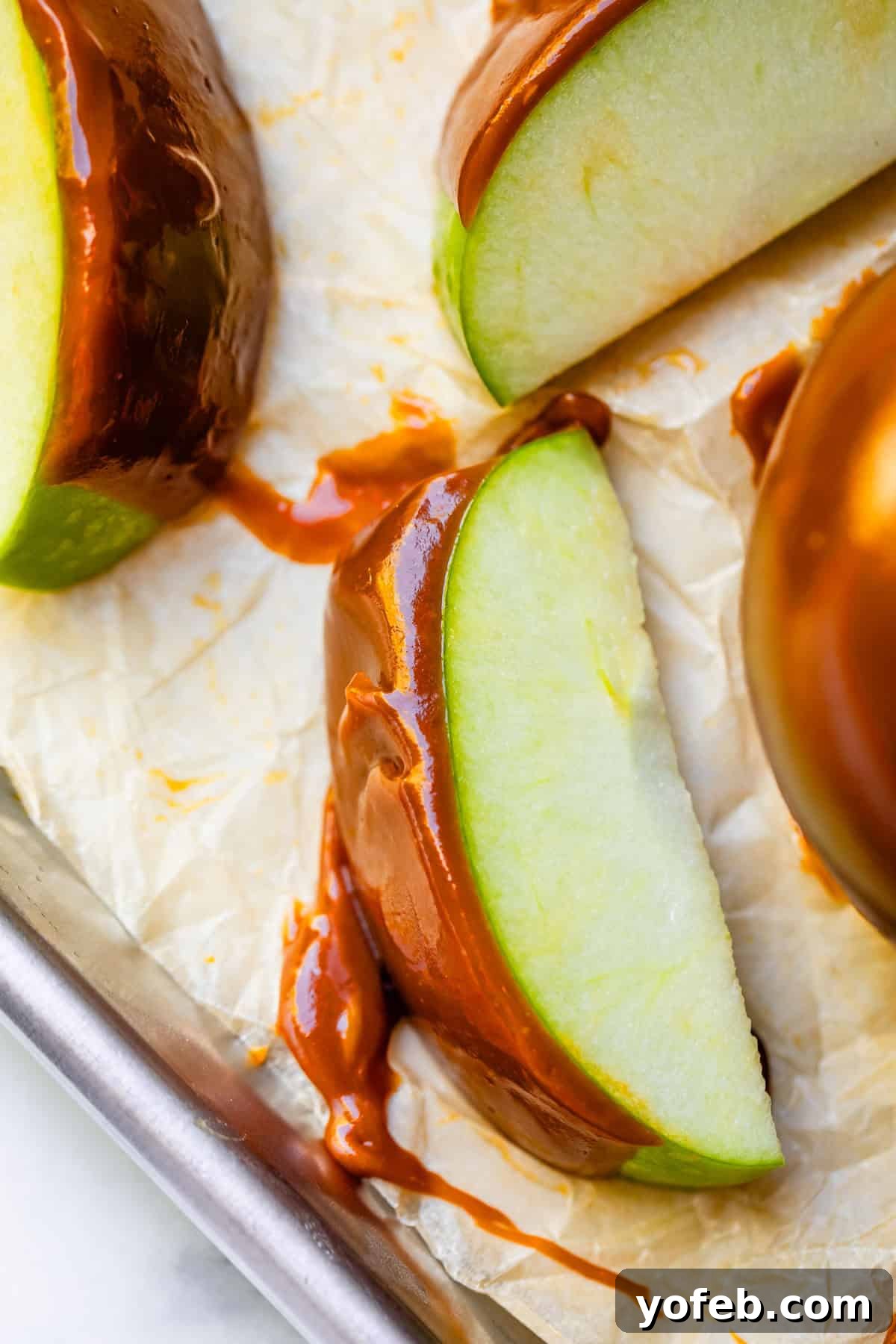 My Ultimate Caramel Apple 7 Elegant slices of caramel apple, beautifully arranged on parchment paper, displaying the smooth, golden caramel coating.