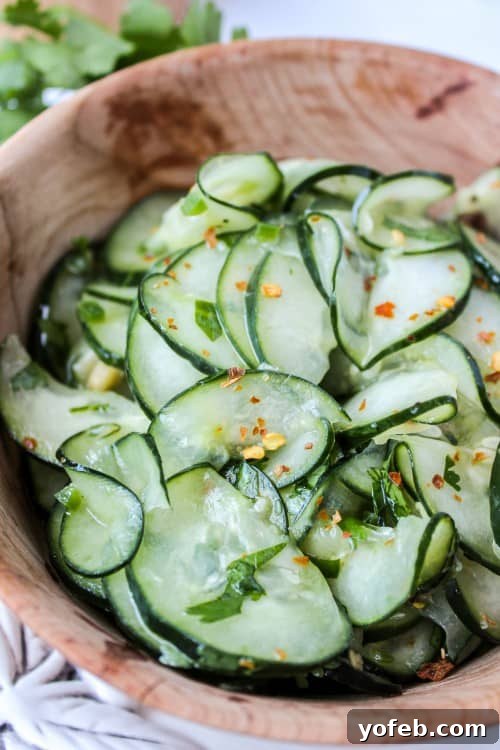Refreshing Mexican Cilantro Lime Cucumber Salad Close-up of a refreshing Mexican cucumber salad with cilantro and lime, beautifully presented in a wooden salad bowl.