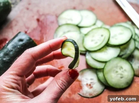 Zesty Mexican Cucumber Salad 3 A hand showing a cucumber slice that is too thick and rigid for optimal salad texture.