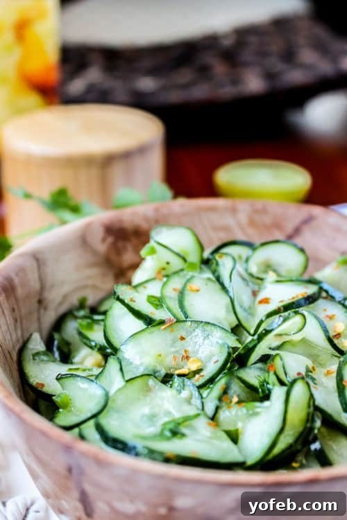 Ready-to-serve Cilantro Lime Cucumber Salad Beautifully dressed Mexican cucumber salad with fresh cilantro and lime in a charming wooden salad bowl.