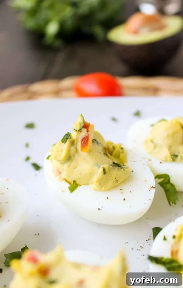 Deviled Guacamole Eggs arranged on a white platter, ready to serve