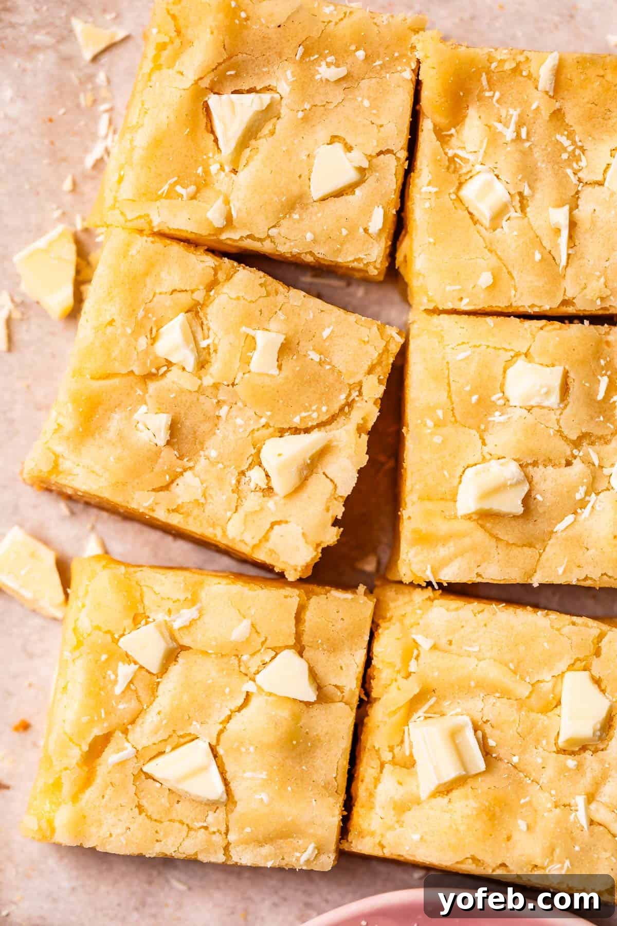 Irresistible White Chocolate Brownies 8 Six perfectly cut squares of fudgy white chocolate brownies arranged on parchment paper, ready to be enjoyed.