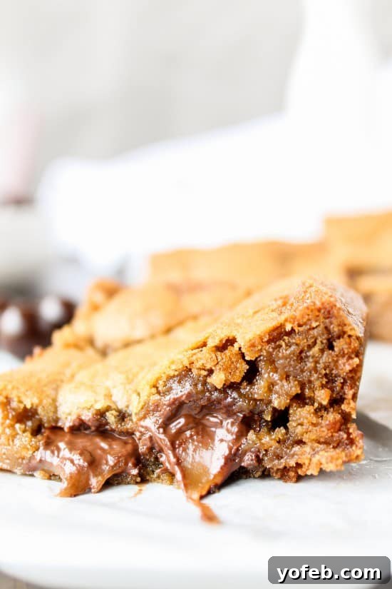 Browned Butter Blondies Swirled with Sea Salt Butterscotch Caramels 6 A hand reaching for a browned butter blondie, showcasing the desire for this sweet treat.
