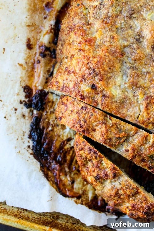 Ina Garten's 1770 House Meatloaf 3 A meticulously shaped raw meatloaf, ready for baking, resting on a parchment-lined baking sheet, showcasing its perfect form.