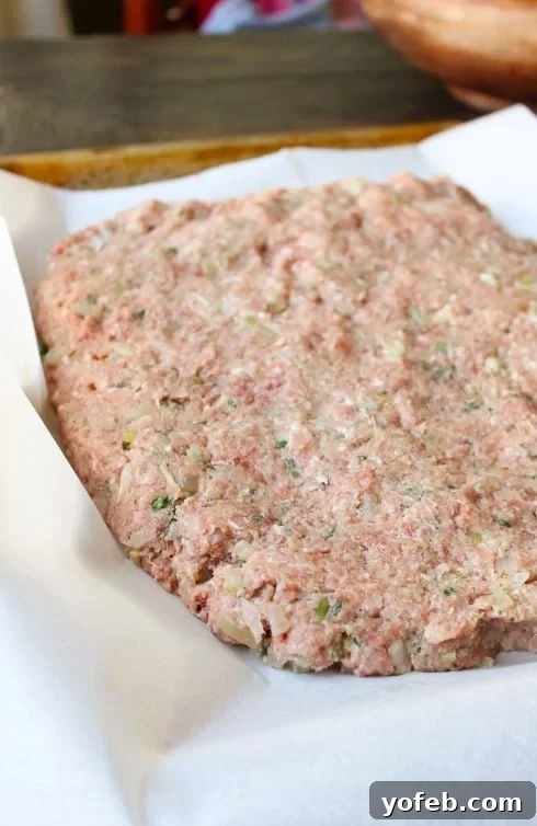 Ina Garten's 1770 House Meatloaf 7 Raw meatloaf mixture expertly shaped into a rectangle, ready to be molded into a cylinder and baked on a parchment-lined baking sheet.