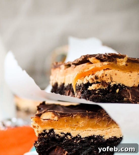 Ultimate Snickers Brownie Treat 8 Close-up of the gooey caramel layer being spread on Snickers Brownie Bars