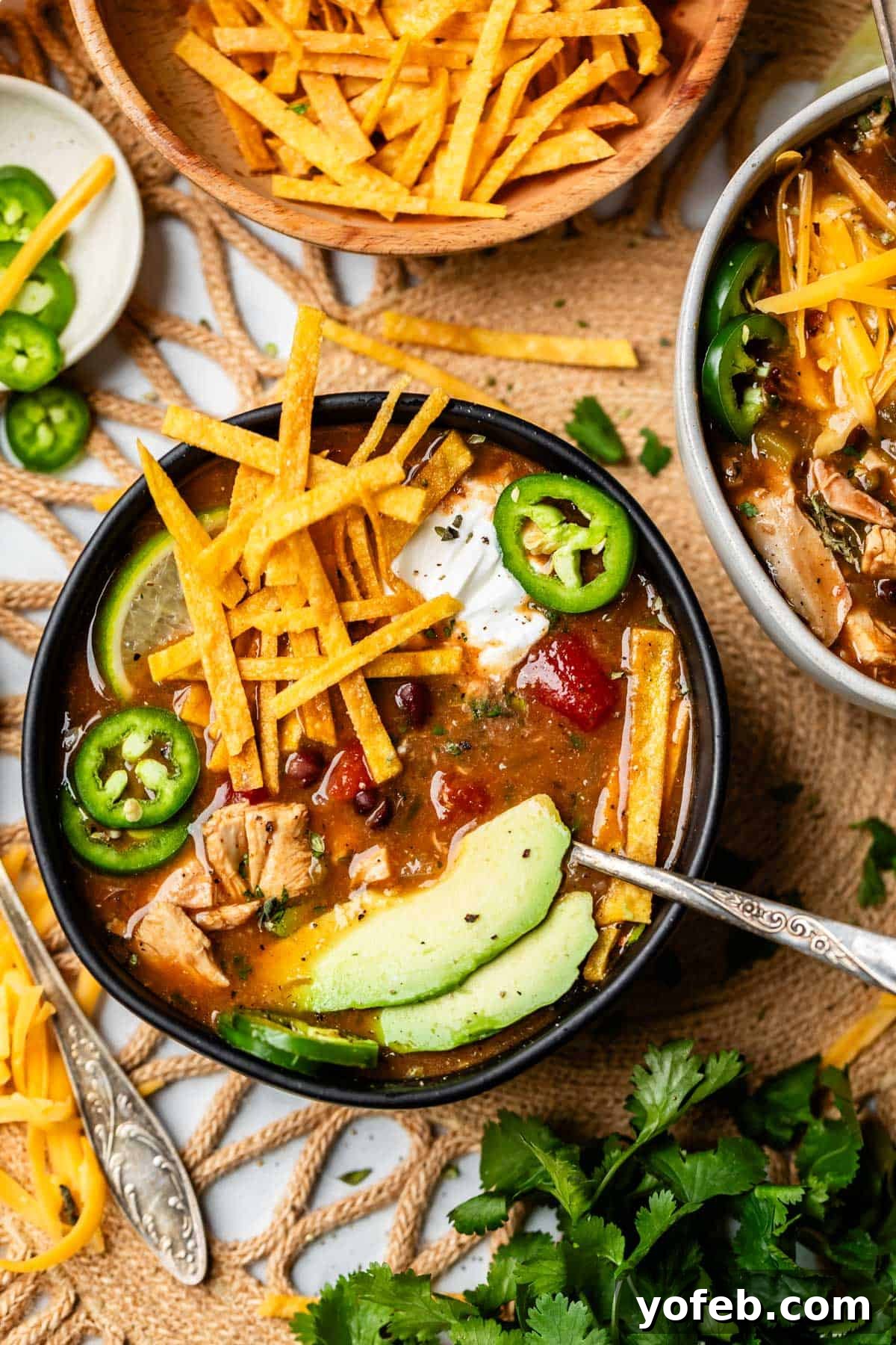 No-Fuss Chicken Tortilla Soup 6 table setting with a few bowls of chicken tortilla soup with toppings.