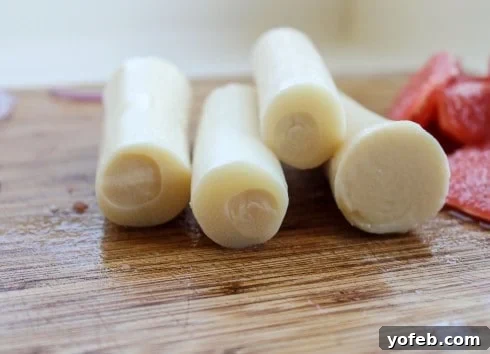 Hearts of Palm being sliced on a cutting board, preparing them for a vibrant salad