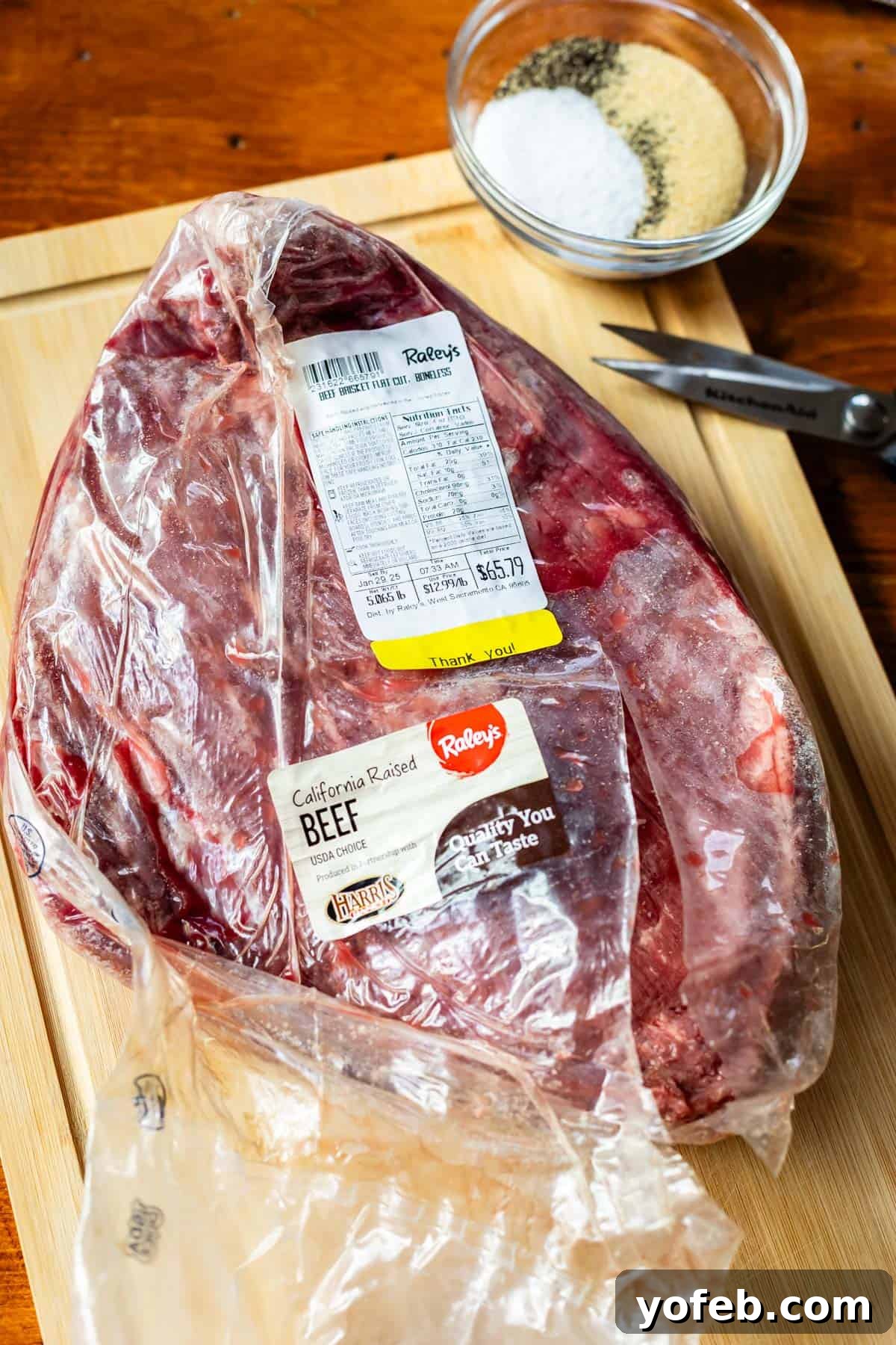 Texas Brisket: Oven-Perfected Tenderness 13 raw brisket in its vacuum sealed packaging sitting on a cutting board.