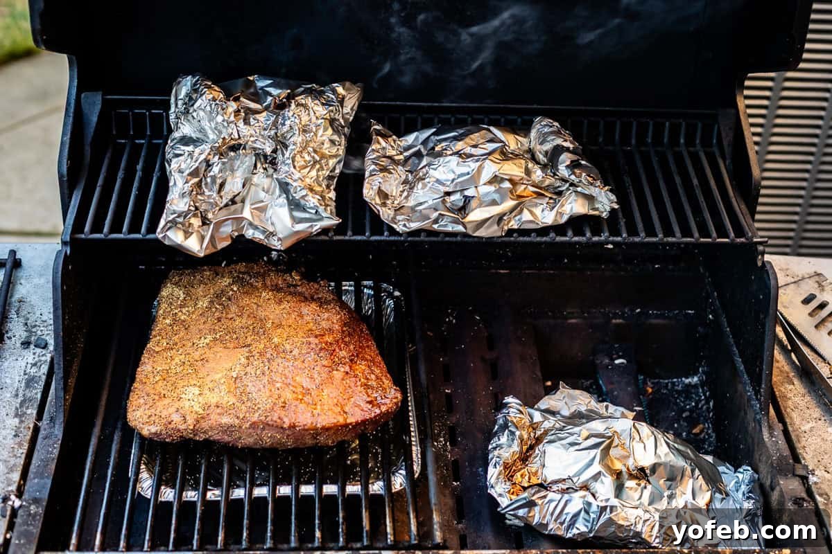Texas Brisket: Oven-Perfected Tenderness 23 3 foil packets in a grill with a brisket.