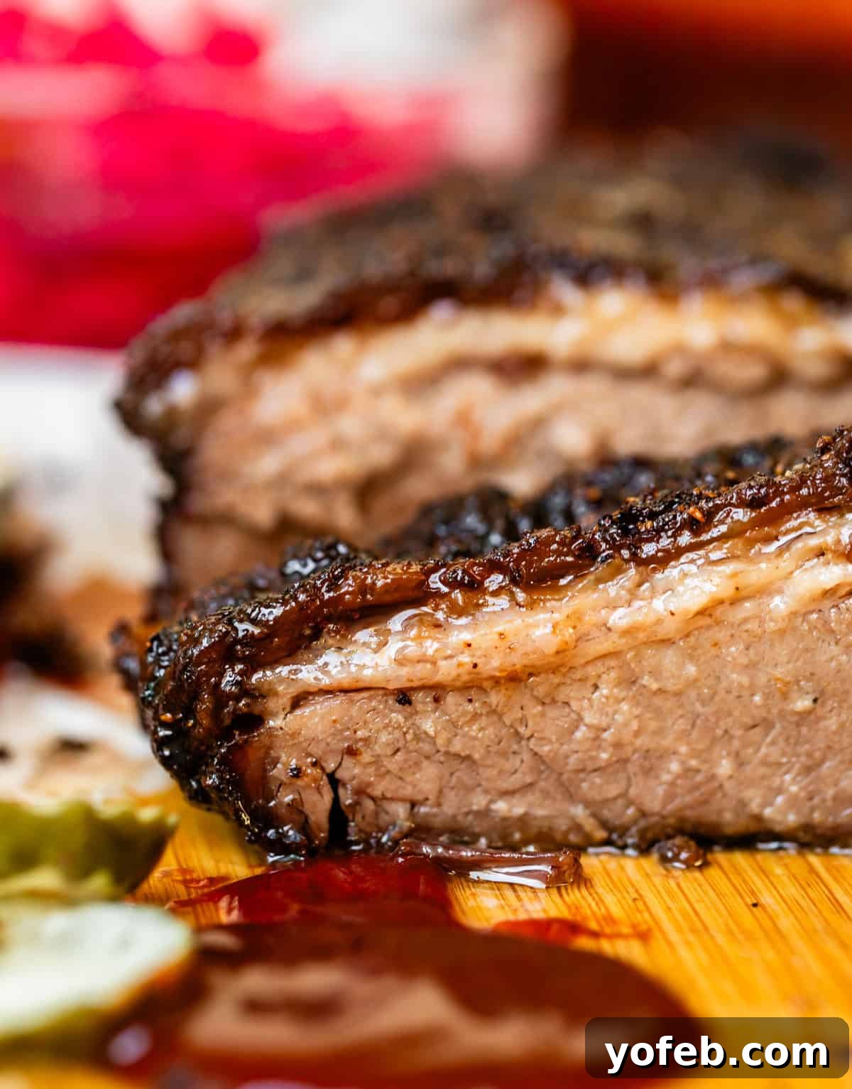 Texas Brisket: Oven-Perfected Tenderness 5 Crosscut section of beef brisket on cutting board with pickles.
