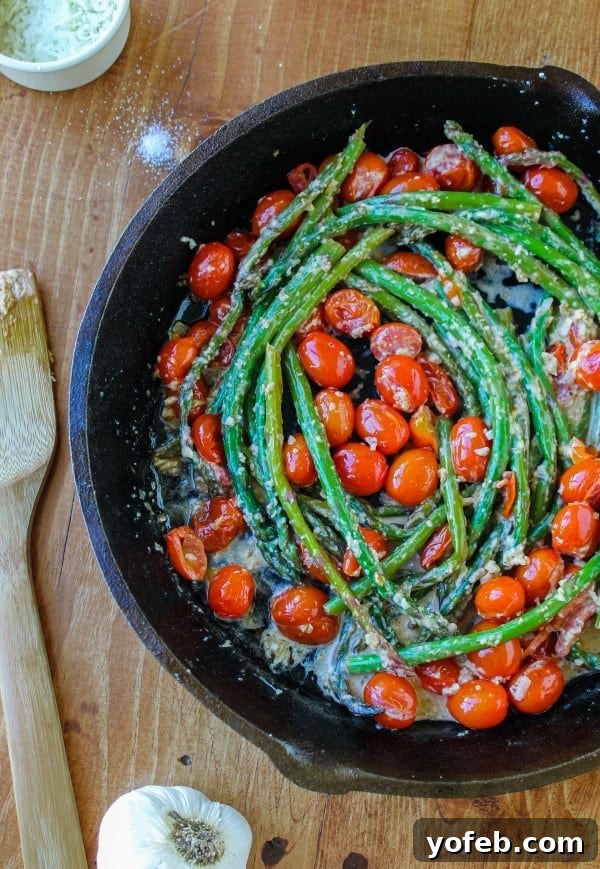 Crisp Asparagus and Tomato Medley 2 Vibrant sautéed asparagus and cherry tomatoes glistening in a cast iron skillet, ready to be served.