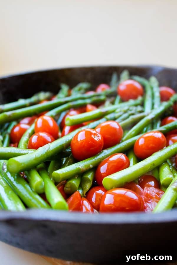Crisp Asparagus and Tomato Medley 9 Sautéed asparagus and cherry tomatoes arranged in a cast iron skillet, showcasing the vibrant colors and appealing texture.