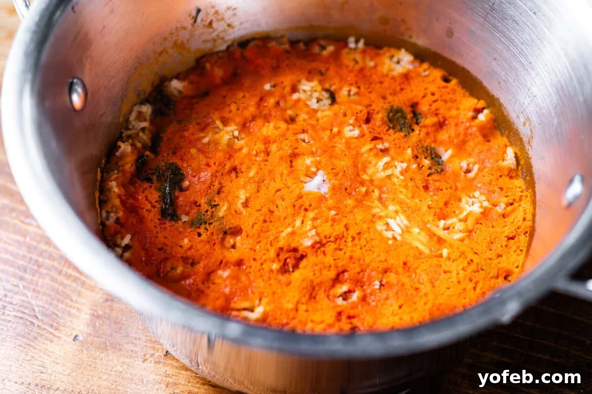 The Ultimate Homemade Mexican Rice 10 cooked Mexican rice in pot with a lot of the sauce sitting on the top of the rice.