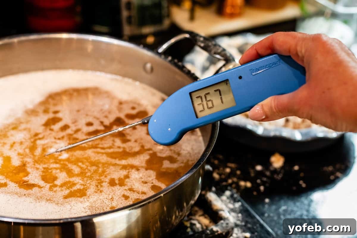 Ultimate Orange Chicken 14 A hand holding an instant-read thermometer to accurately check the temperature of the frying oil.