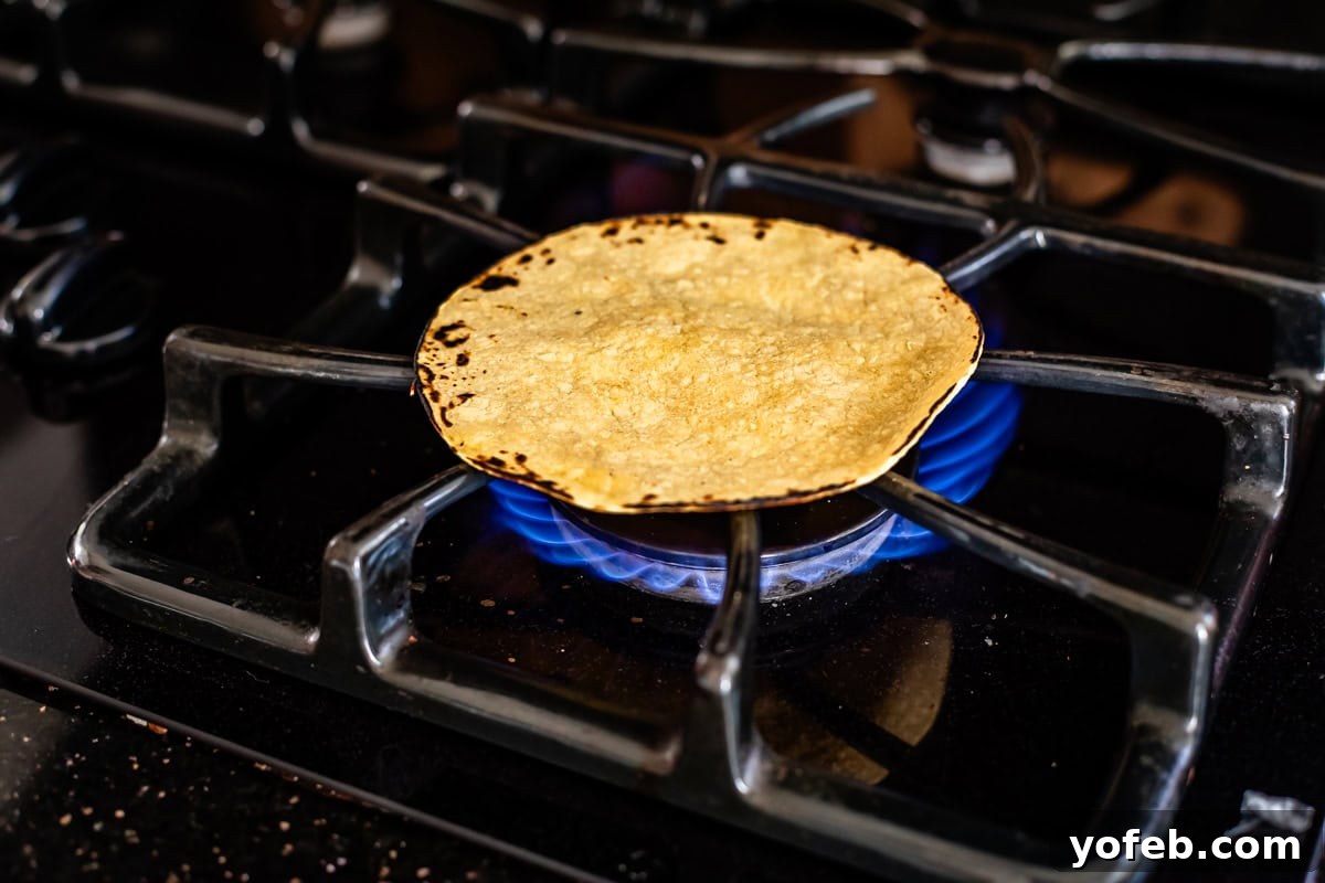 Yeni Gözdem Tavuk Enchilada 14 charred corn tortilla directly on burner over flame on a gas stove.