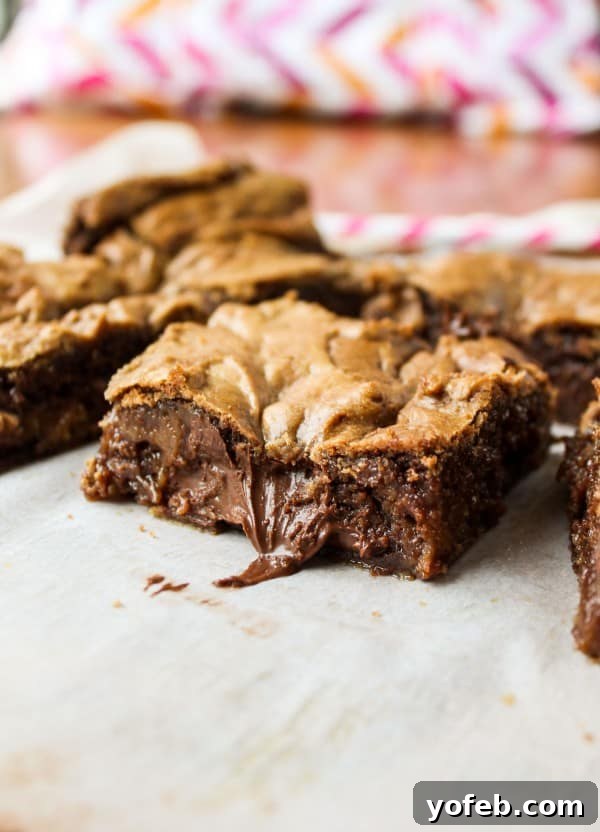 Decadent Browned Butter Blondies with a Gooey Nutella Heart 5 A slice of Nutella-stuffed blondie on a plate, highlighting its soft, chewy interior and delectable appearance.