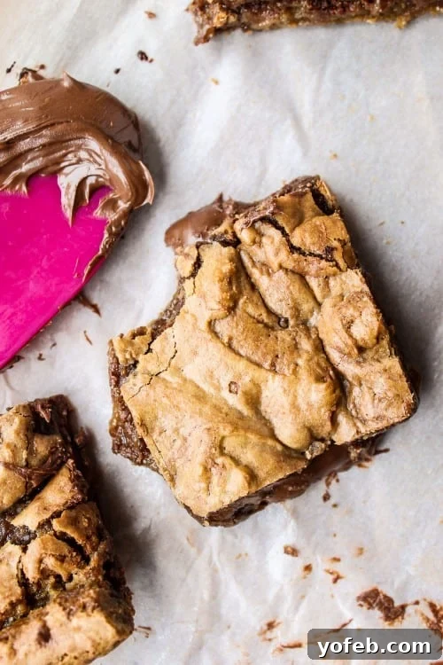 Decadent Browned Butter Blondies with a Gooey Nutella Heart 7 A close-up shot of a Nutella-stuffed blondie, with a visible, delicious Nutella center oozing out, making it an irresistible dessert.