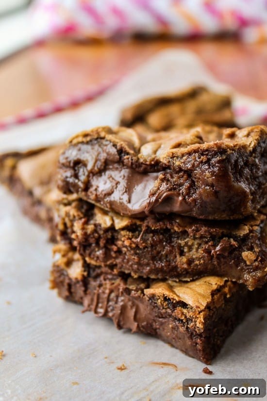 Decadent Browned Butter Blondies with a Gooey Nutella Heart 8 Overhead view of several Nutella-stuffed blondies, cut into squares, ready to be served.