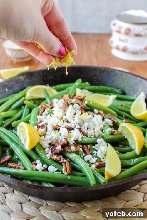 Zesty Green Beans with Creamy Feta and Crispy Pecans 12 Garnishing the finished Lemon Green Beans with Feta and Fried Pecans with fresh lemon zest.