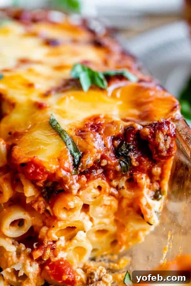 Garnished Baked Ziti: A Cheesy and Herbaceous Delight. A stunning close-up of baked ziti with cheese and fresh basil, highlighting the rich texture and vibrant colors.